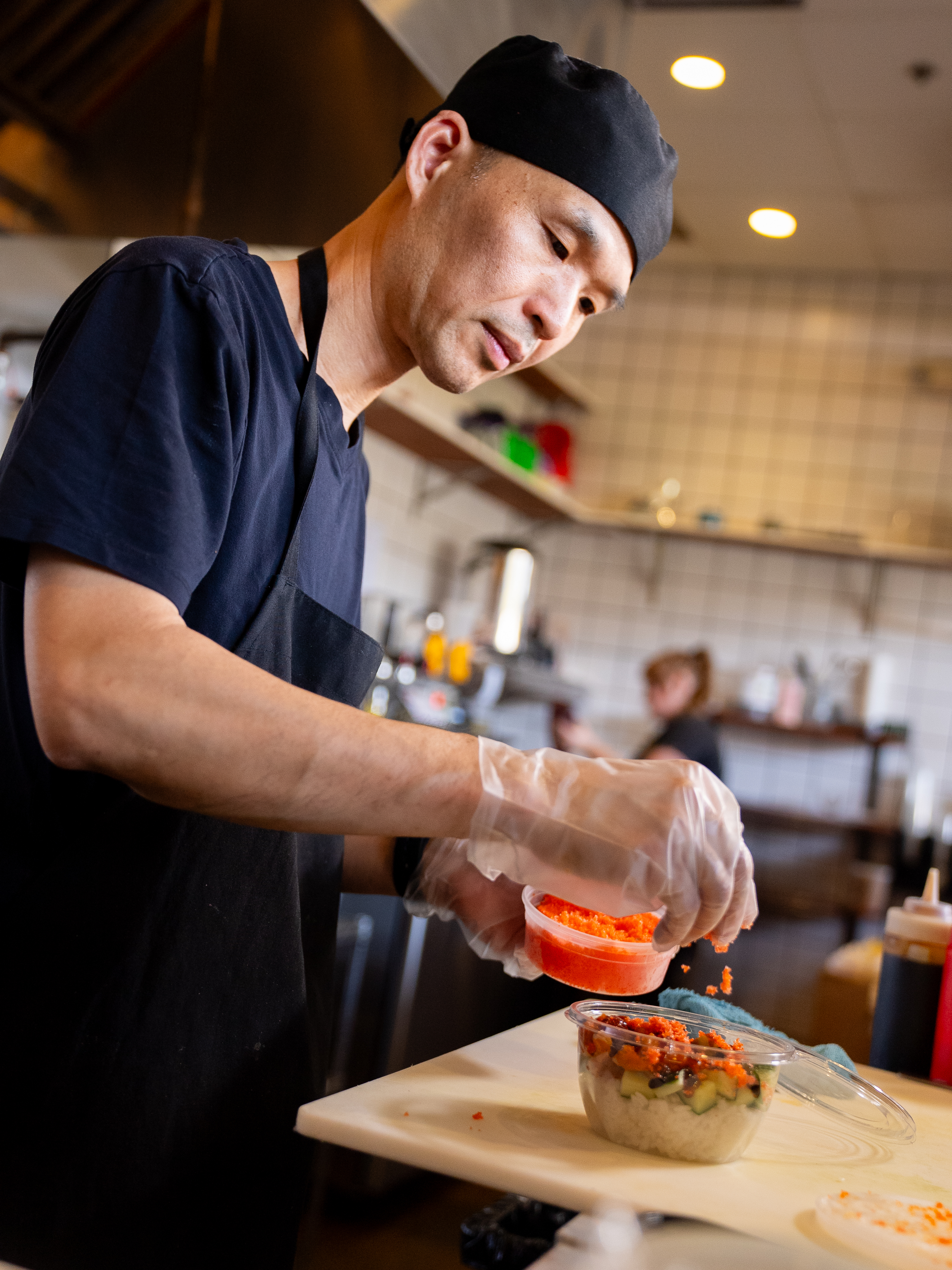 Chef making a sushi bowl.